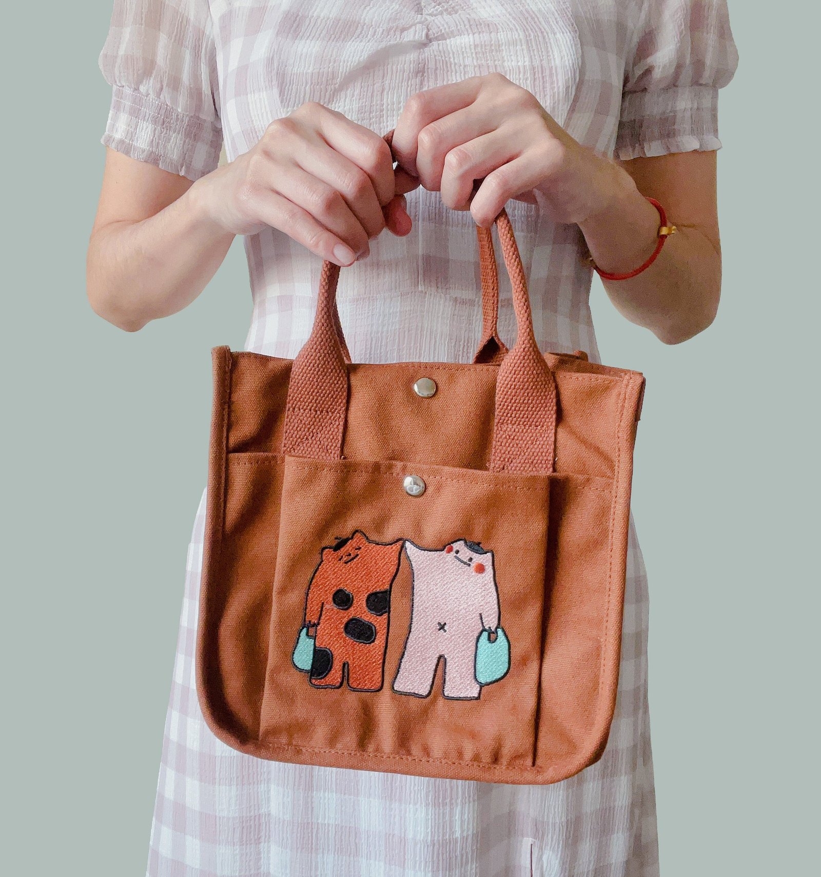 the model is carrying a Purple Times Mochi Tiger Boxy Tote